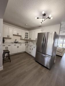 a kitchen with a stainless steel refrigerator and white cabinets at my place to be in Port Charlotte