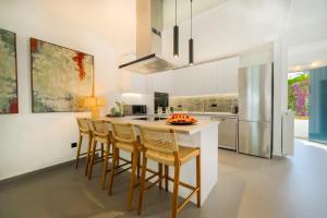 a kitchen with a island with bar stools at Barbati Beachfront - Pool Villa in Barbati