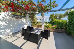a group of chairs sitting on a patio with flowers at Barbati Beachfront - Pool Villa in Barbati
