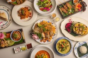 ein Tisch mit Tellern voller Essen in der Unterkunft MORA Boutique Hotel in Chiang Rai