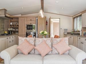 a living room with a couch with pillows at Deer Glade Lodge in Landford