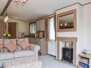 a living room with a couch and a mirror at Deer Glade Lodge in Landford