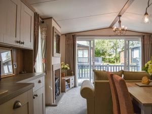 a kitchen and living room with a couch and a table at Deer Glade Lodge in Landford