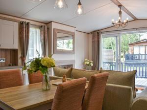 a kitchen and dining room with a table and chairs at Deer Glade Lodge in Landford
