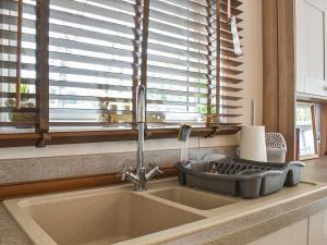 a sink in a kitchen with a window at Deer Glade Lodge in Landford +6 photos