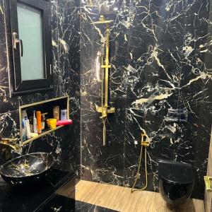 a black marble bathroom with a sink and a mirror at Villa Jenna in Kelibia +7 photos