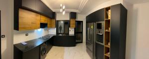 a large kitchen with black cabinets and a black counter top at Villa Jenna in Kelibia