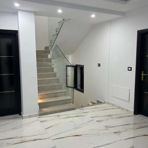 a hallway with a staircase with white walls and marble floors at Villa Jenna in Kelibia