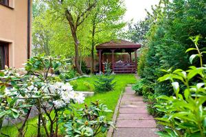 a garden with a gazebo in the background at Villa Ventana Poznań City Free Parking Śniadanie w Cenie in Poznań