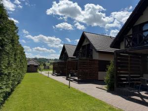 a row of wooden barns with a pathway in front at Agroturystyka Ostoja Wilków I in Wilków