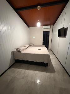 a bedroom with a bed and a television in it at Vila do Tênis in Guaratinguetá