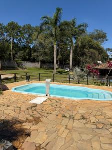 a swimming pool with a chair in a yard at Vila do Tênis in Guaratinguetá +45 photos