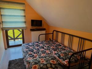 a bedroom with a bed with a floral bedspread and a window at Agroturystyka Ostoja Wilków I in Wilków