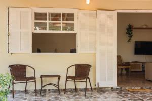a group of chairs sitting in a living room with a window at Casa Laguna - Geribá in Búzios