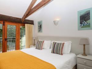 a bedroom with a white bed and a window at Fixit Cottage in Kingsbridge +27 photos