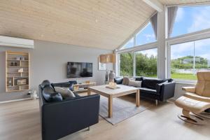 a living room with couches and a table at Feriehus 1120 in Ringkøbing