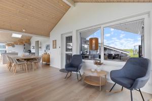 a living room with a table and chairs and a large window at Feriehus 1120 in Ringkøbing