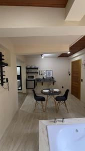 a kitchen and living room with a table and chairs at Green Valley Hydro Suite - Monte Verde-MG in Camanducaia