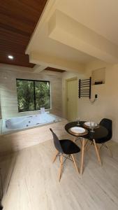 a living room with a tub and a table and chairs at Green Valley Hydro Suite - Monte Verde-MG in Camanducaia