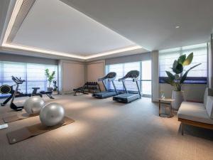 a gym with exercise equipment in a room with windows at Mercure Chengdu Dongjiao Memory in Chengdu