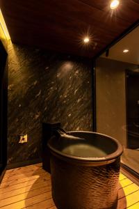 a large bath tub in a room with a wall at OOkami Villa in Omachi +22 photos