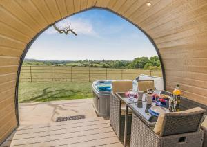 a gazebo with a table and chairs on a patio at Firtree Farm Lodges in Yeovil