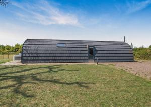 a large black building with a door in a field at Firtree Farm Lodges in Yeovil +34 photos