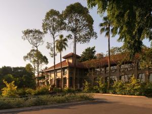 a building with palm trees in front of it at Raffles Sentosa Singapore in Singapore