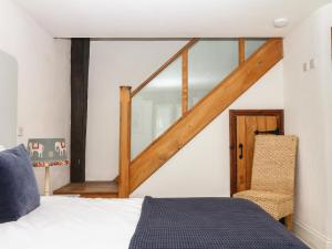 a bedroom with a bed and a wooden stair case at Mixit Cottage in Kingsbridge +27 photos