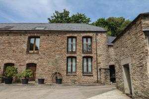 an old brick building with windows on it at Mixit Cottage in Kingsbridge
