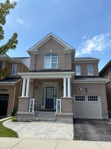 a brown brick house with a white garage at The Basement apartment in Milton