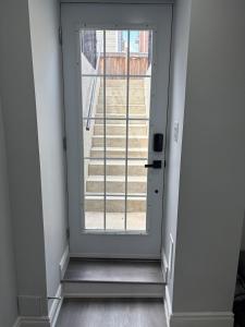 a door leading to a staircase with a window at The Basement apartment in Milton