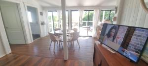 a living room with a tv and a table and chairs at Ocean High in Yamba