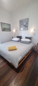 two beds in a bedroom with two lamps on the wall at Ocean High in Yamba