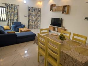 a living room with a table and a blue couch at Residence Emilienne in Cotonou