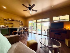 a living room with a couch and a ceiling fan at Warm, private, poolside retreat in Cable Beach
