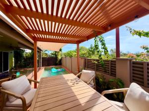 a wooden deck with a table and chairs on a patio at Warm, private, poolside retreat in Cable Beach