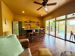 a kitchen and living room with a ceiling fan at Warm, private, poolside retreat in Cable Beach