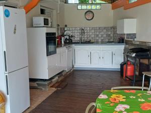 a kitchen with white cabinets and a white refrigerator at Le Refuge de Nicolas in Quartier Morne Acajou