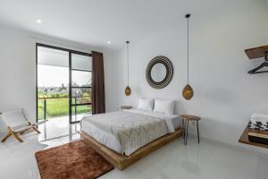 a white bedroom with a large bed and a mirror at Villa Alba by Orivista, Rice Field View in Dalung +18 photos