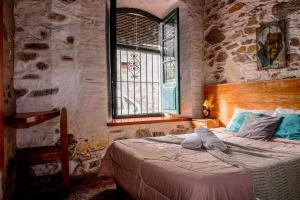 a bedroom with a bed in a room with a window at Posada San Gabriel in Colonia del Sacramento