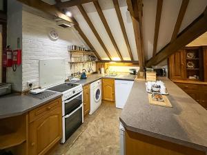 a large kitchen with a stove and a sink at Granary - Uk51016 in Louth +19 photos