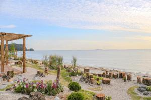 a beach with a pavilion and flowers and the water at Seesun Art Studio Villa in Ansan