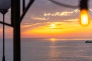 a sunset over the ocean with a boat in the water at Samcheok Pureun Bada Pension in Samcheok +13 photos