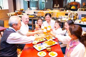 a group of people sitting around a table with drinks at Hotel Flags Sasebo KujuKusima in Sasebo