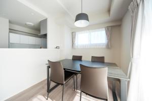 a dining room with a black table and chairs at Formosa Hills in Kumamoto