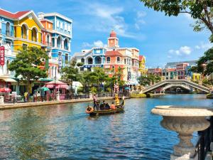 a group of people in a boat on a river with buildings at Lam Stay Grand World Phu Quoc in Phú Quốc