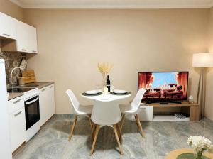 a kitchen with a table and a tv on a wall at The Central Nest in Bečej
