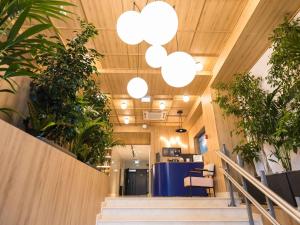 an office lobby with potted plants and lights at Mercure Bucharest Cantemir in Bucharest