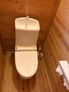 a white toilet in a room with wooden walls at YAMAYA BASE 1 in Ōkawamochi